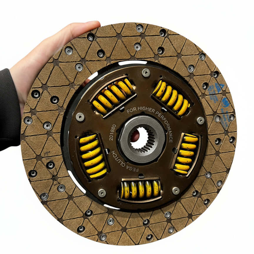 Clutch disc held by a hand on a white background