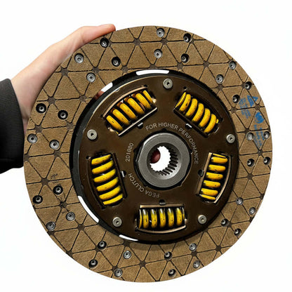 Clutch disc held by a hand on a white background